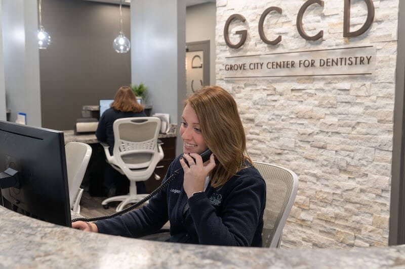 receptionist at Grove City Center for Dentistry answering phone call about emergency dental care visit